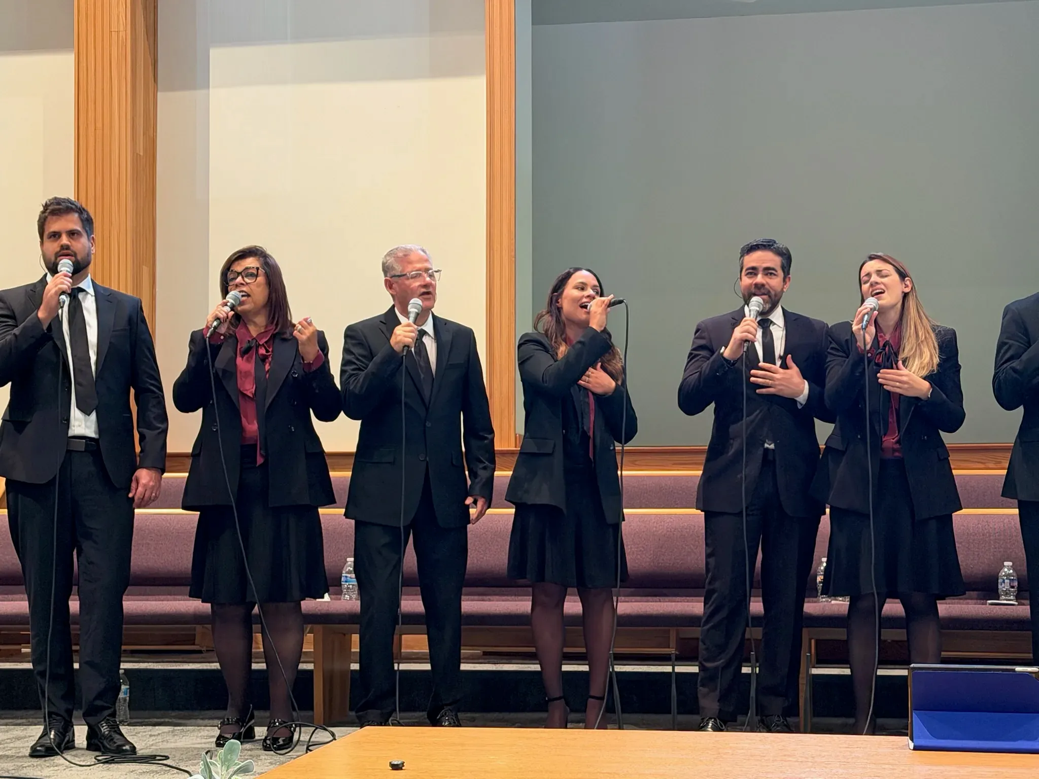Prisma USA singing in a line across a church platform